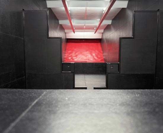 Indoor shooting range with red bullet trap and black barricade