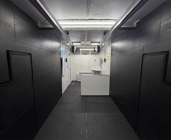 Forward view of an indoor shooting range with black soundproof walls